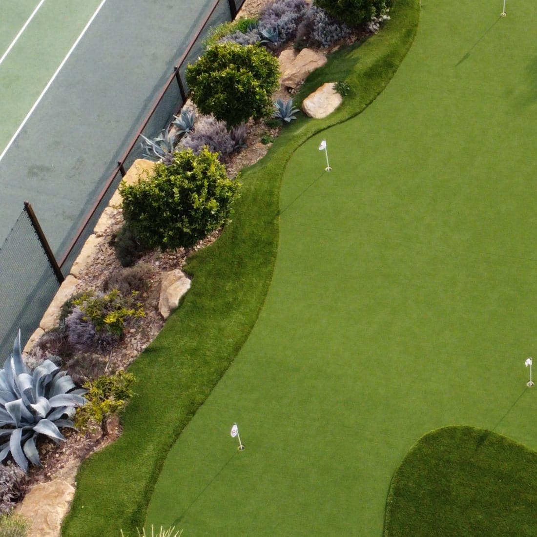 Aerial view of a Riviera Grass synthetic green integrated with desert landscaping in Dubai